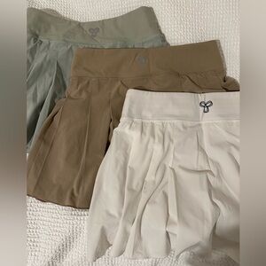 3 TNA ARITZIA TENNIS SKIRTS — SAGE, TAN, WHITE